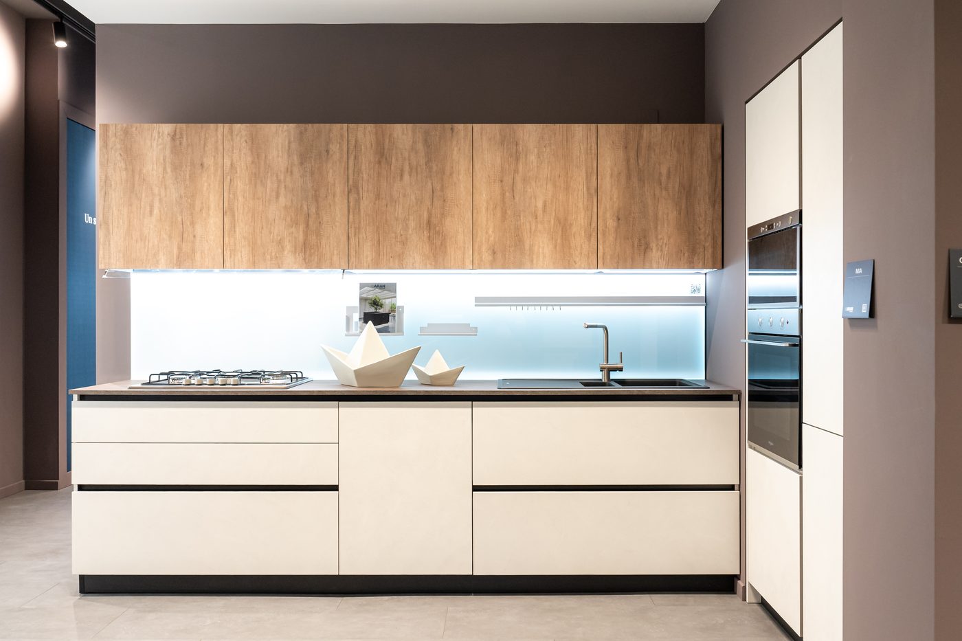 Cucina lineare con basi bianche e pensili in legno