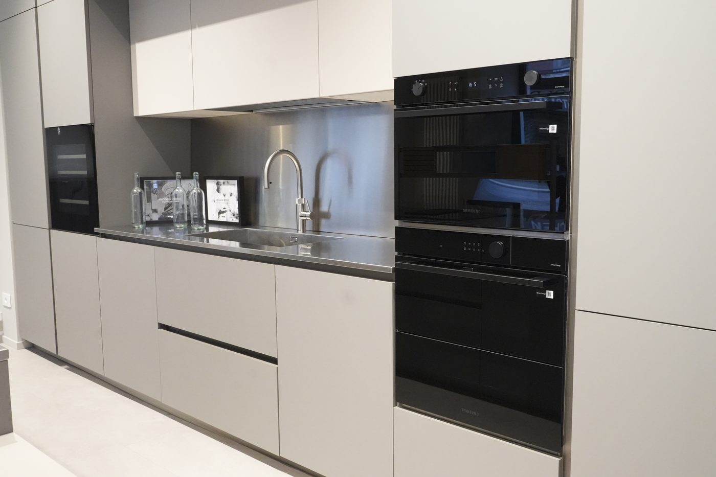 Cucina grigia con colonne forno e lavello in acciaio
